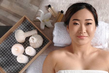 Beautiful Asian woman lying on massage table in salon, top viewの写真素材