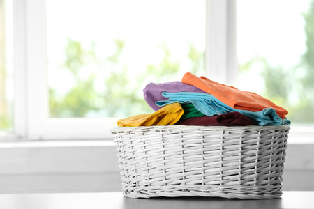 Basket with clean laundry on table at home, space for textの写真素材