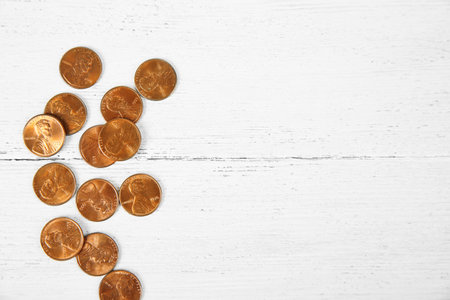 Many coins on wooden table, top view. Space for text