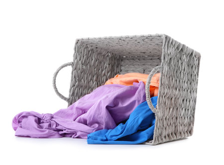 Laundry basket with scattered dirty clothes isolated on whiteの写真素材