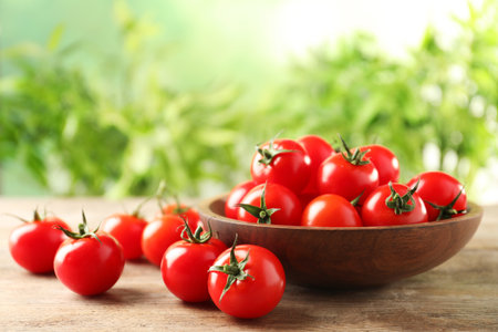 Bowl of fresh cherry tomatoes on wooden tableの写真素材