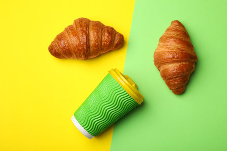 Paper coffee cup and croissants on color background, flat layの写真素材