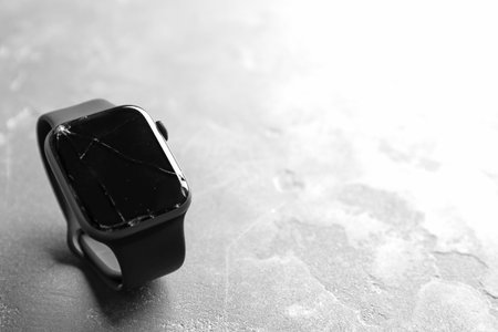 Broken smart watch on gray background, space for text. repair serviceの写真素材