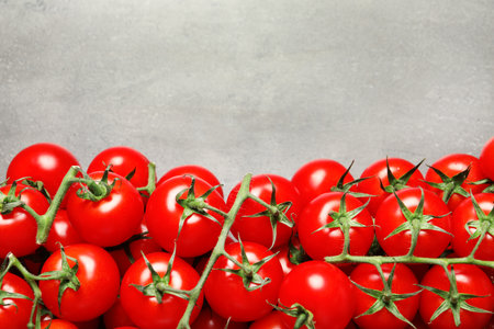 Heap of fresh cherry tomatoes on stone background, top view. Space for textの写真素材