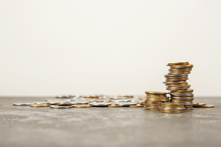 Many coins on table against light background, space for text