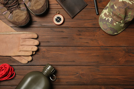 Flat lay composition with camping equipment on wooden background. Space for textの写真素材