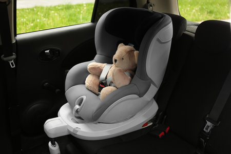 Teddy bear in child safety seat inside car. Danger preventionの写真素材