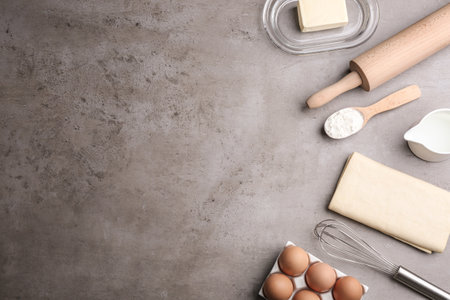 Flat lay composition with fresh dough on gray table, space for text. puff pastryの写真素材