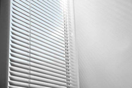 Window with closed horizontal blinds indoors, low angle view. Space for textの写真素材