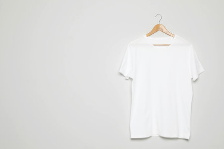 Hanger with blank t-shirt on white background. Mock up design