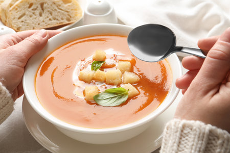 Woman eating sweet potato soup at table, closeupの写真素材