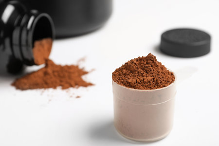 Measuring scoop with protein powder on table. Space for textの写真素材
