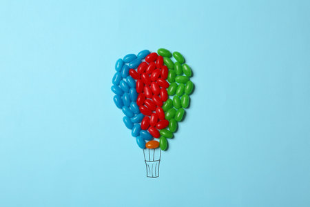 Bright jelly candies arranged as air balloon on color background, flat layの写真素材