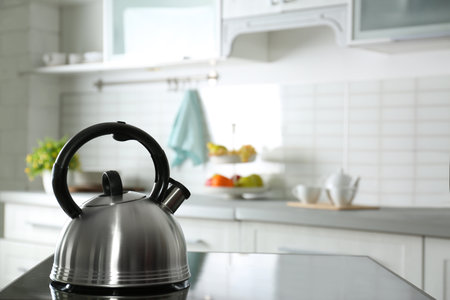 Modern kettle with whistle on stove in kitchen, space for textの写真素材