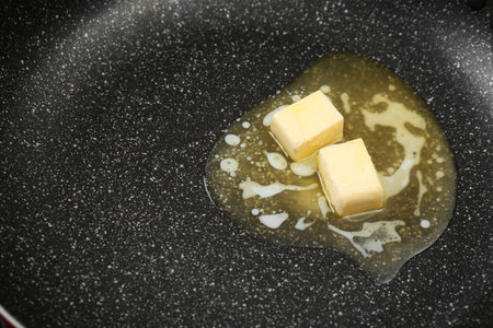 Butter melting on frying pan, closeup viewの写真素材