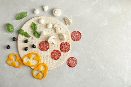 Flat lay composition with base and ingredients for pizza on marble table, space for textの写真素材