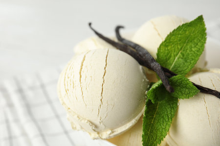 Delicious vanilla ice cream with mint on table, closeup. Space for textの写真素材