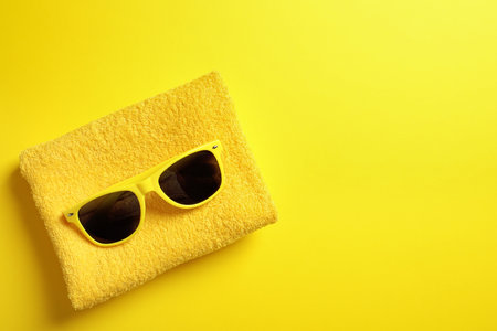 Sunglasses and towel on color background, top view with space for text. beach accessoriesの写真素材