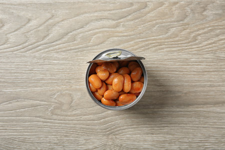 Open tin can of beans on wooden background, top viewの写真素材