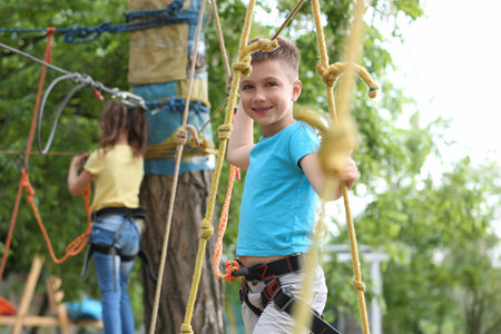 Little boy climbing in adventure park. summer campの写真素材