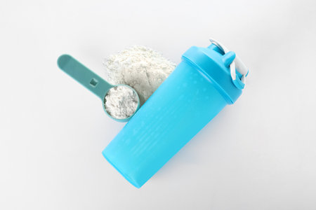 Scoop of protein powder and sports bottle isolated on white, top view