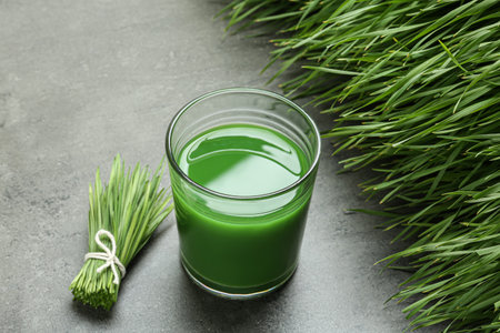 Composition with glass of wheat grass juice on gray stone backgroundの写真素材