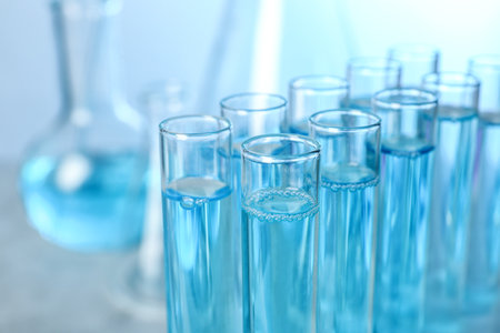 Test tubes with liquid on blurred background, closeup with space for text. solution chemistryの写真素材