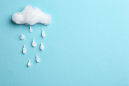 Cloud and raindrops made of cotton on blue background, flat lay. Space for textの写真素材