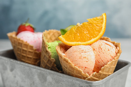 Delicious ice creams in waffle cones served on table, closeupの写真素材