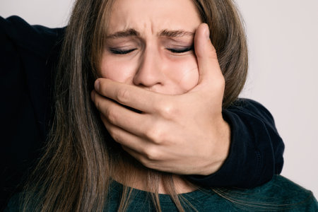 Man abusing young woman on light background. Stop sexual assaultの写真素材