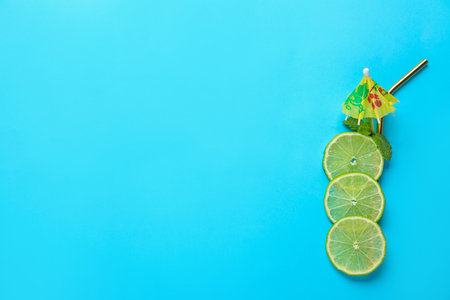 Creative image of summer cocktail made with lime slices, mint and straw on color background, top view. Space for textの写真素材