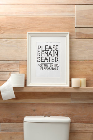 Toilet bowl and funny sign near wooden wall. bathroom interiorの写真素材