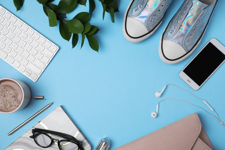 Frame made of blogger's stuff on blue background, top view. Space for textの写真素材