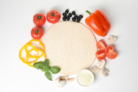 Composition with pizza crust and fresh ingredients isolated on white, top viewの写真素材