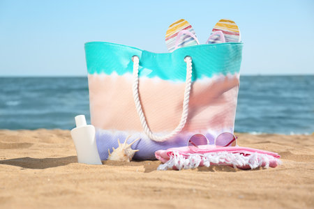 Stylish beach accessories on sand near the seaの写真素材