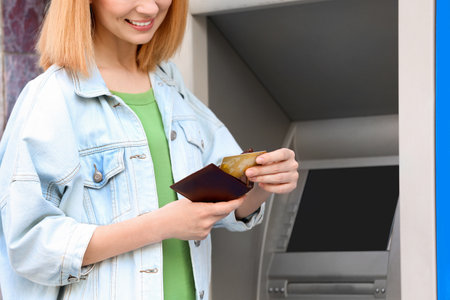 Woman with credit card near cash machine outdoors, closeupの写真素材