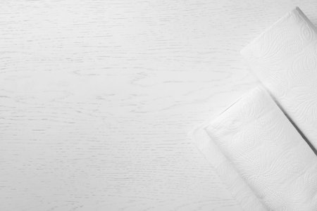 Rolls of paper towels on wooden table, top view. Space for textの写真素材