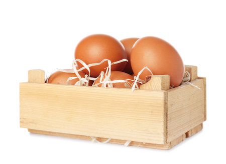 Wooden crate full of fresh eggs on white backgroundの写真素材
