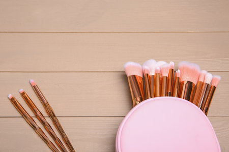 Set of professional makeup brushes with bag on wooden background, above view. Space for textの写真素材