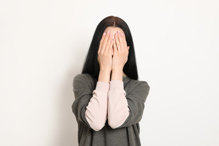 Upset young woman crying against white backgroundの写真素材