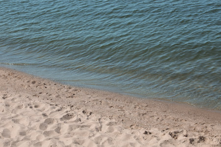 View of sea water and beach sand on sunny summer dayの写真素材