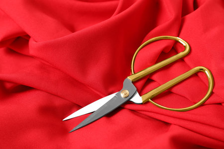 Sharp scissors on red fabric, space for text. Tailoring accessoriesの写真素材
