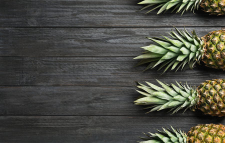 Flat lay composition with fresh juicy pineapples on wooden background, space for textの写真素材