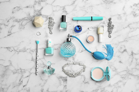 Flat lay composition with perfume bottles, jewelry and decorative cosmetics on white marble tableの写真素材