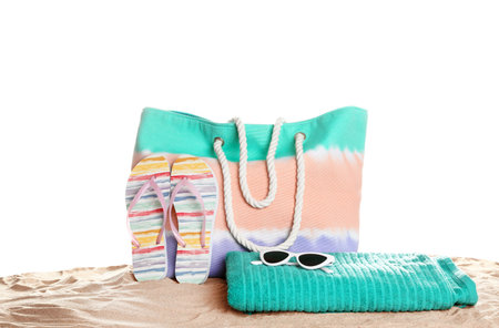 Stylish colorful bag and beach accessories on sand against white backgroundの写真素材