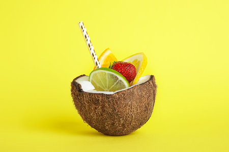 Summer refreshing cocktail in coconut on color backgroundの写真素材