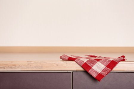 Fabric checkered towel on wooden table in kitchenの写真素材