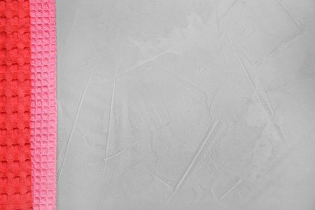 Colorful kitchen towels on gray stone table, top view. Space for text