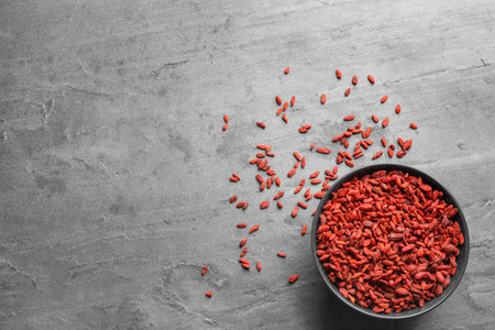 Bowl of dried goji berries on gray table, top view with space for text. healthy superfoodの写真素材