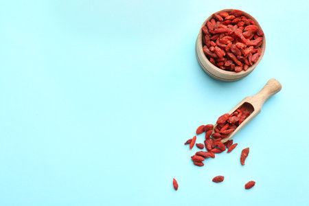 Flat lay composition with dried goji berries on light blue background, space for text. healthy superfoodの写真素材